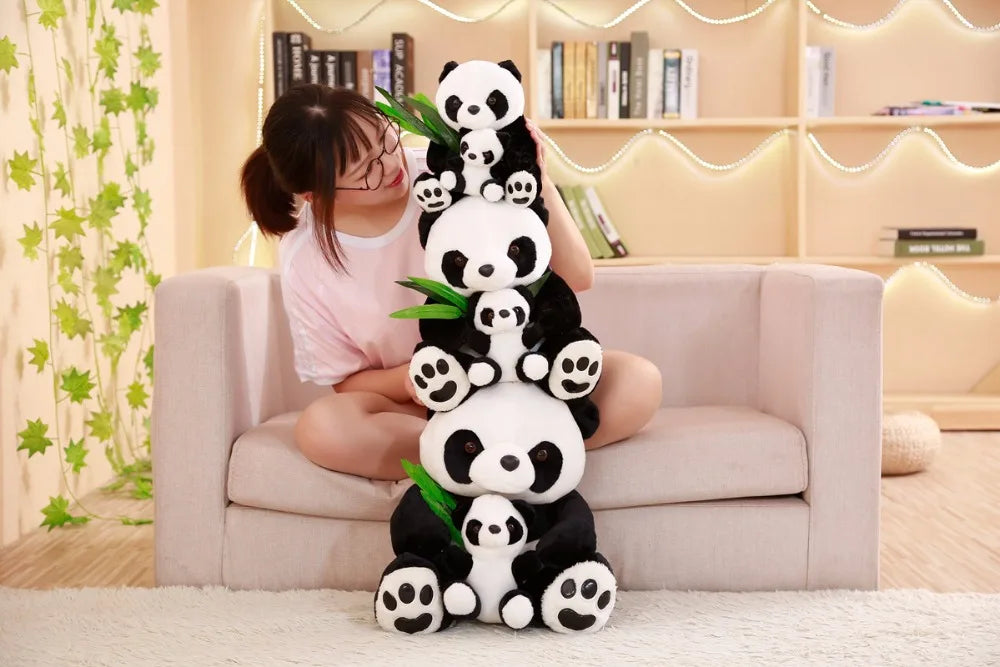 Person holding a stack of panda plush toys in a living room setting.