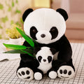 Two panda plush toys with a smaller one holding a leaf on a checkered surface.