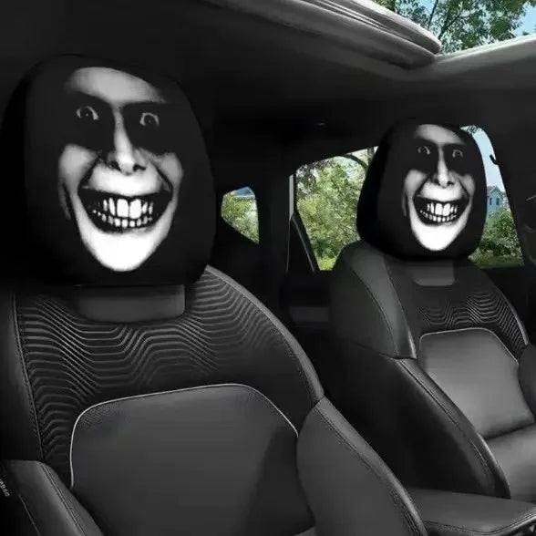 Car interior with headrest covers featuring a smiling face design.