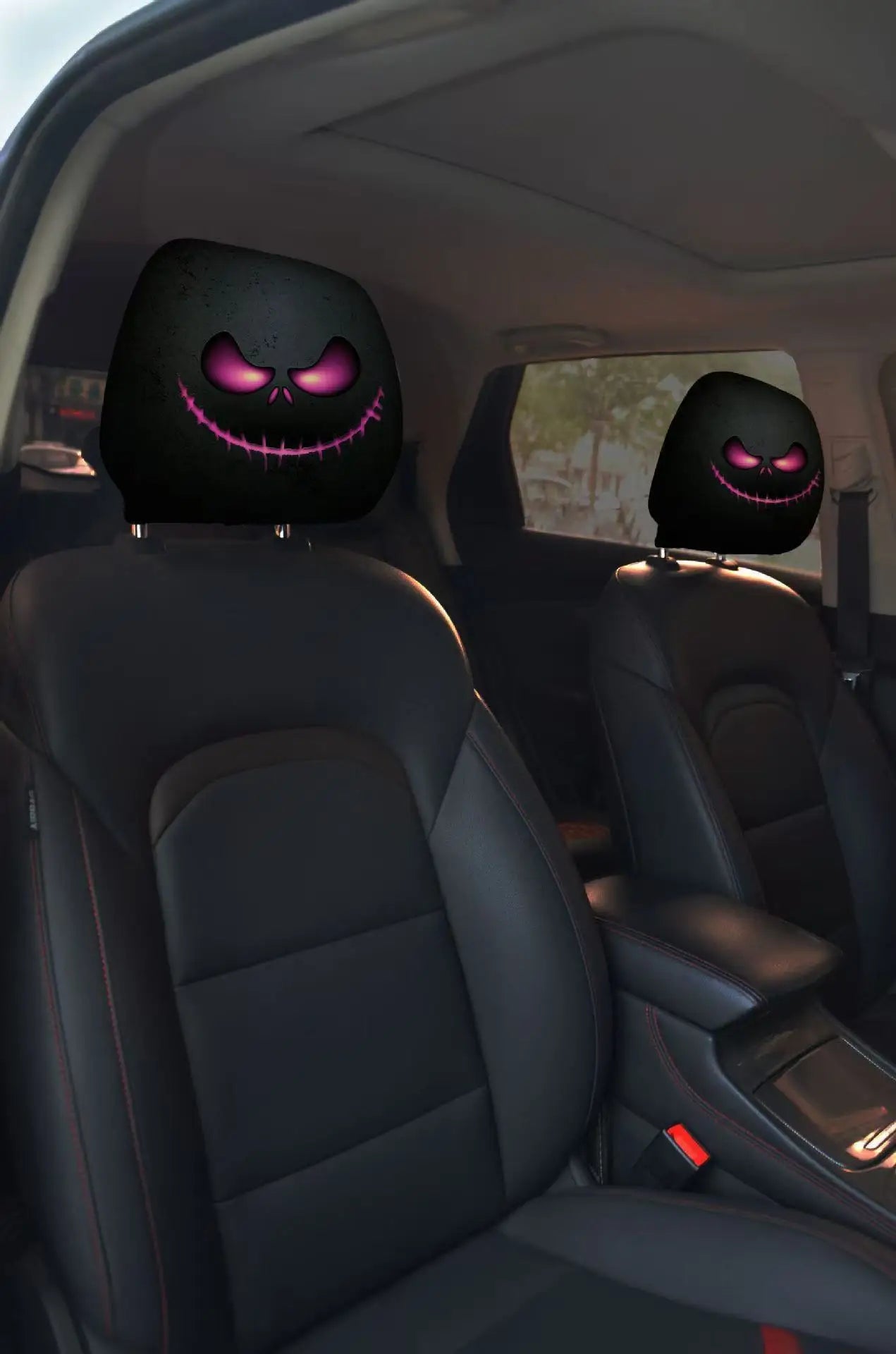 Car interior with black headrest covers featuring glowing pink eyes.