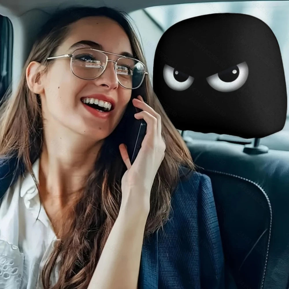 Woman talking on a phone with a cartoonish black mask with eyes in the backseat of a car.