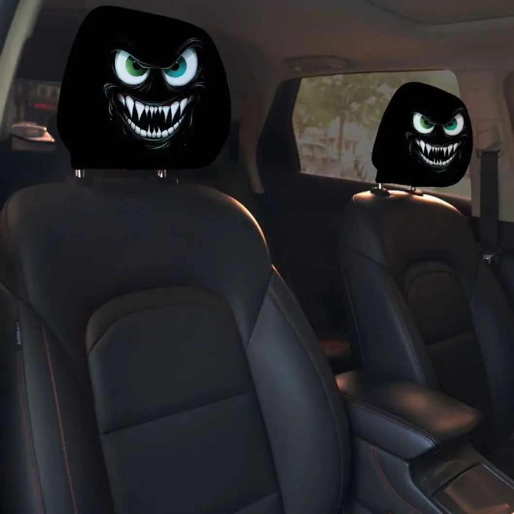 Car interior with black headrest covers featuring angry face designs.